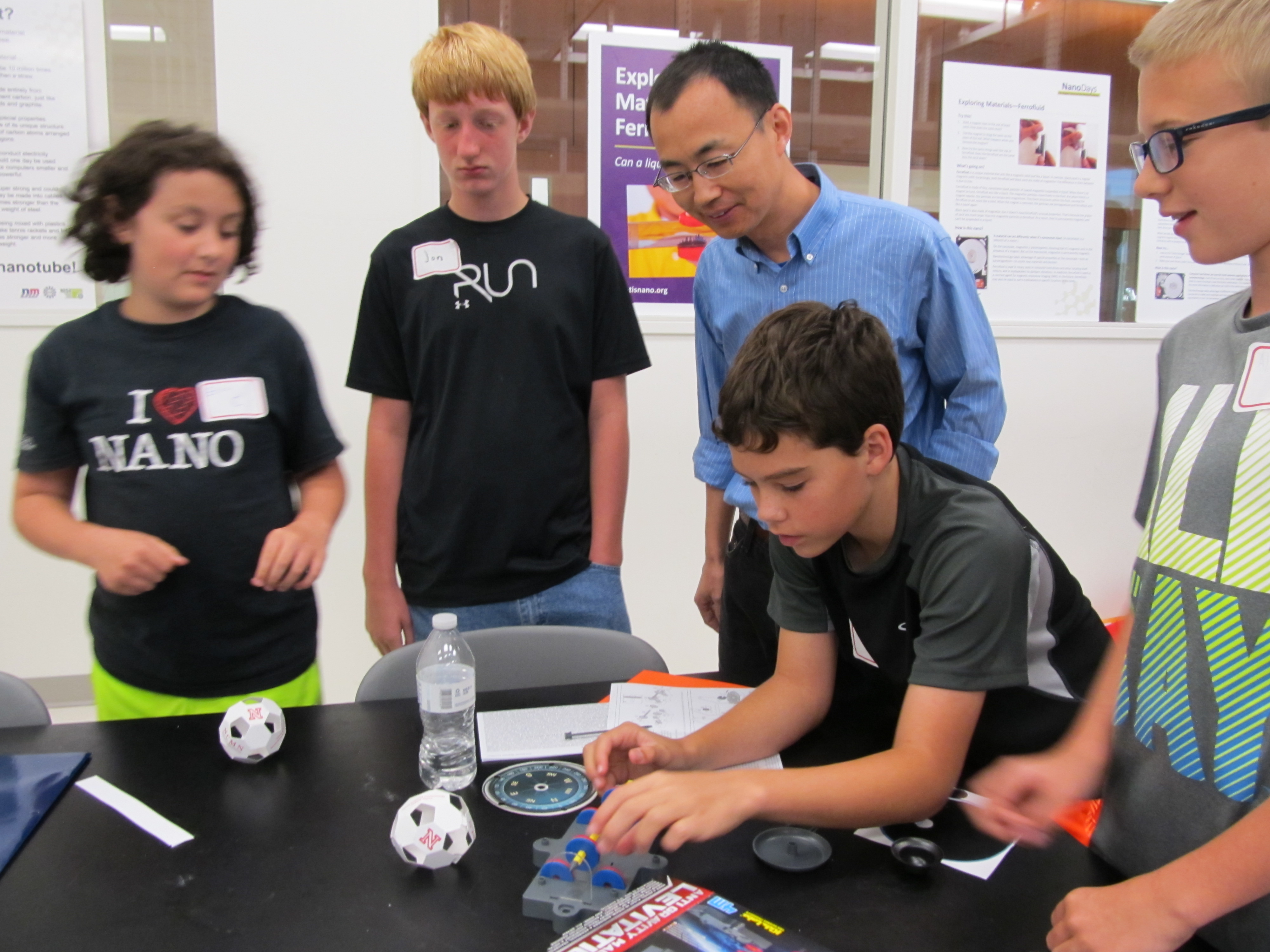 Professor Xu surveys students working on lab apparatus