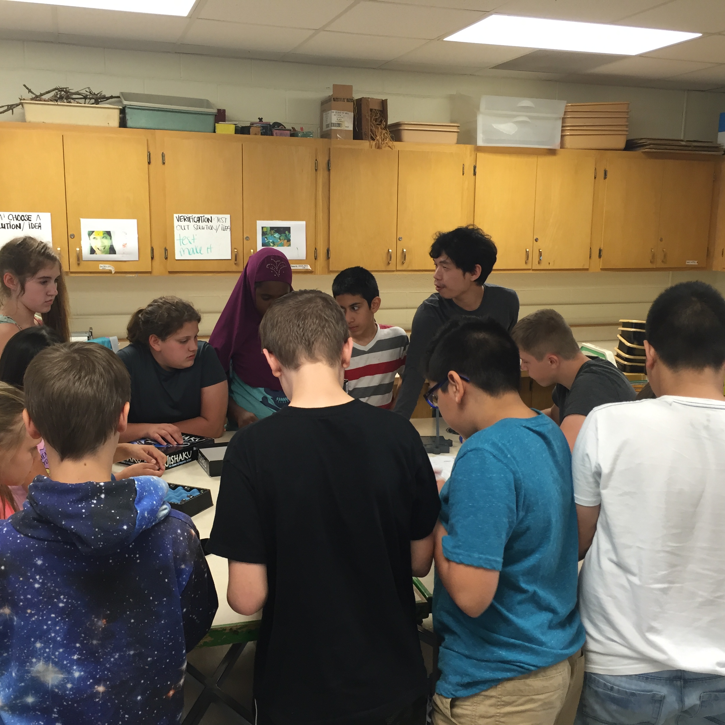 Professor Xu surveys students working on lab apparatus